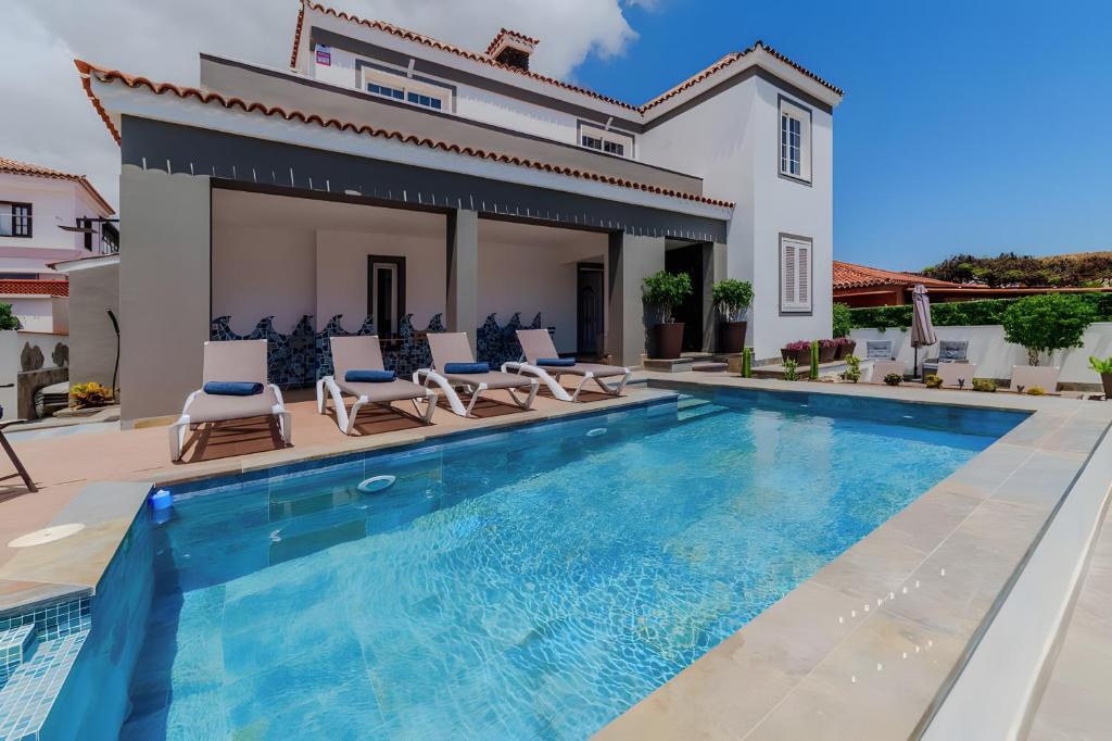 a villa with a swimming pool and a house at Villa De Marcos in Arona