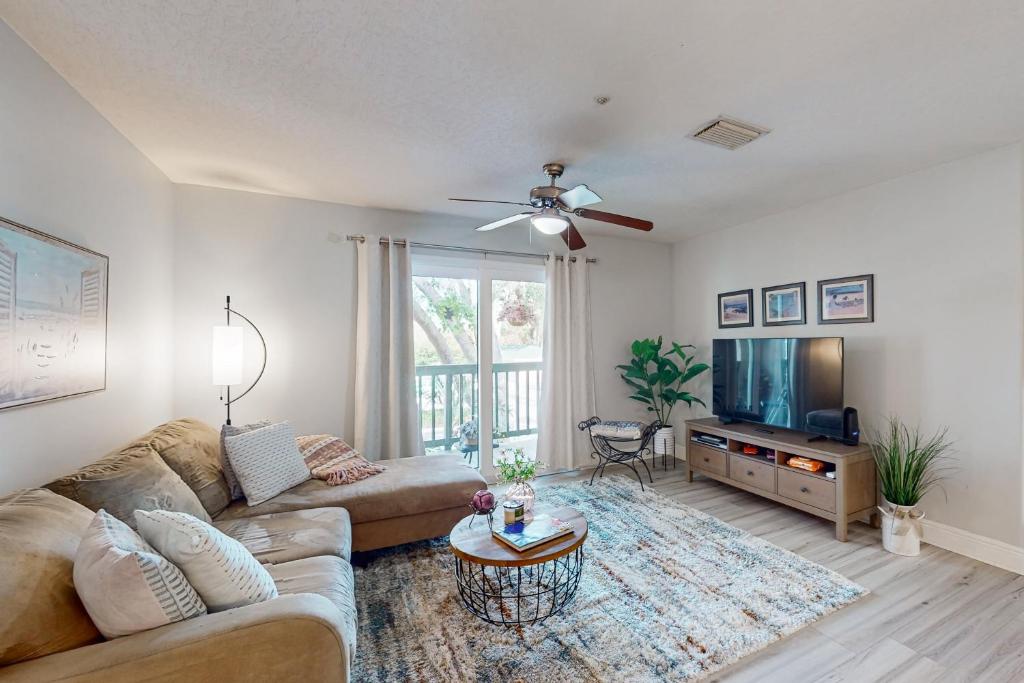 a living room with a couch and a flat screen tv at Cypress Cove 111 in Melbourne