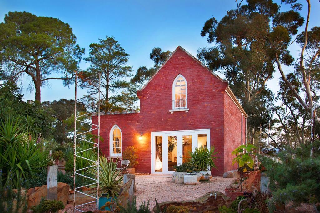 a red brick house with a staircase in front at be&be castlemaine in Castlemaine