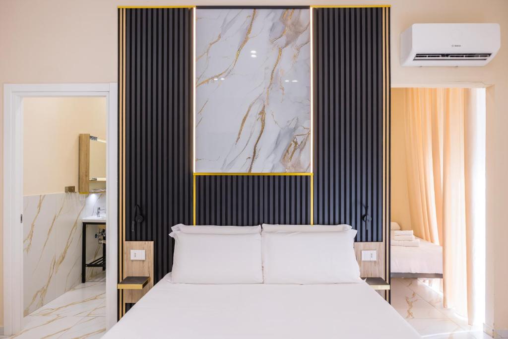 a bedroom with a white bed and a painting on the wall at Partenope Rooms in Naples