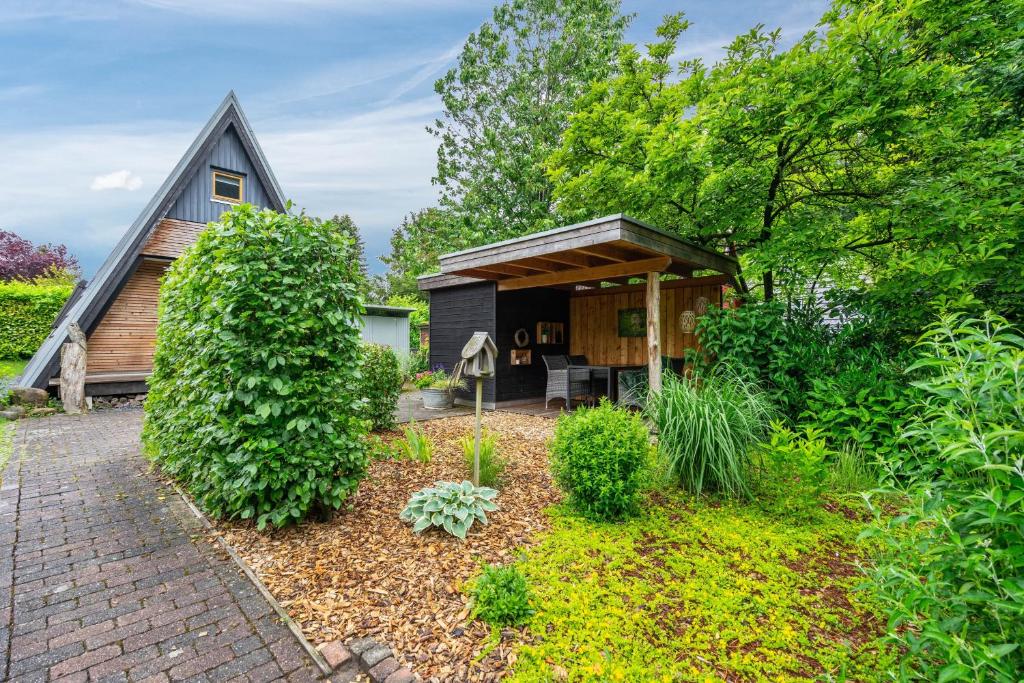 a home with a thatched roof and a garden at Ferienhaus Eulennest in Billerbeck