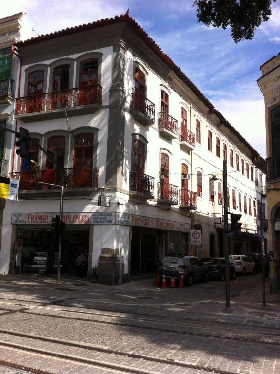 a white building on a street with cars parked in front at Hospedagem Ledo in Rio de Janeiro