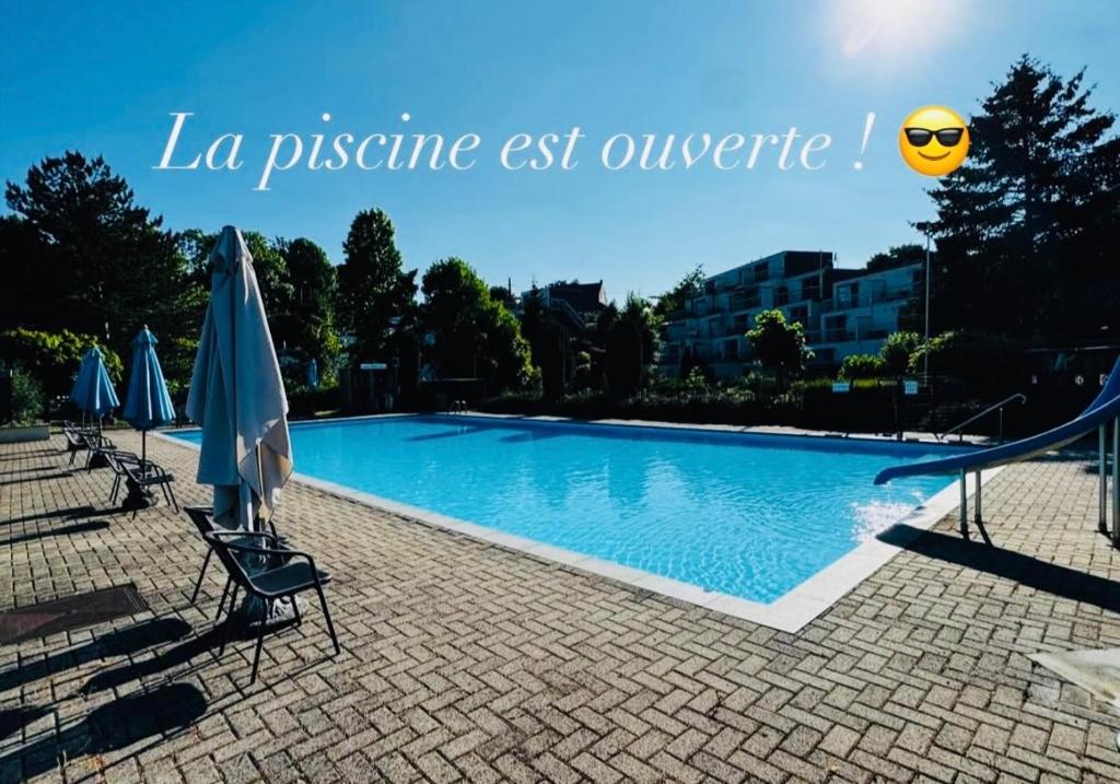 a swimming pool with chairs and an umbrella and a slide at Chez Denis et Jenni I par Mon-Majordome in Han-sur-Lesse