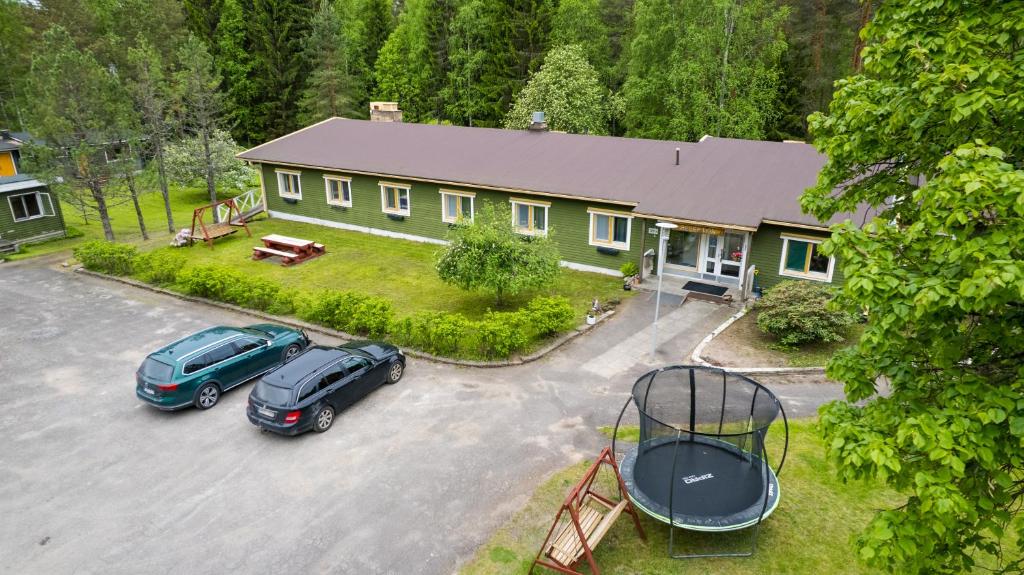 a house with two cars parked in a parking lot at Kyyrönkaita in Kyyrö