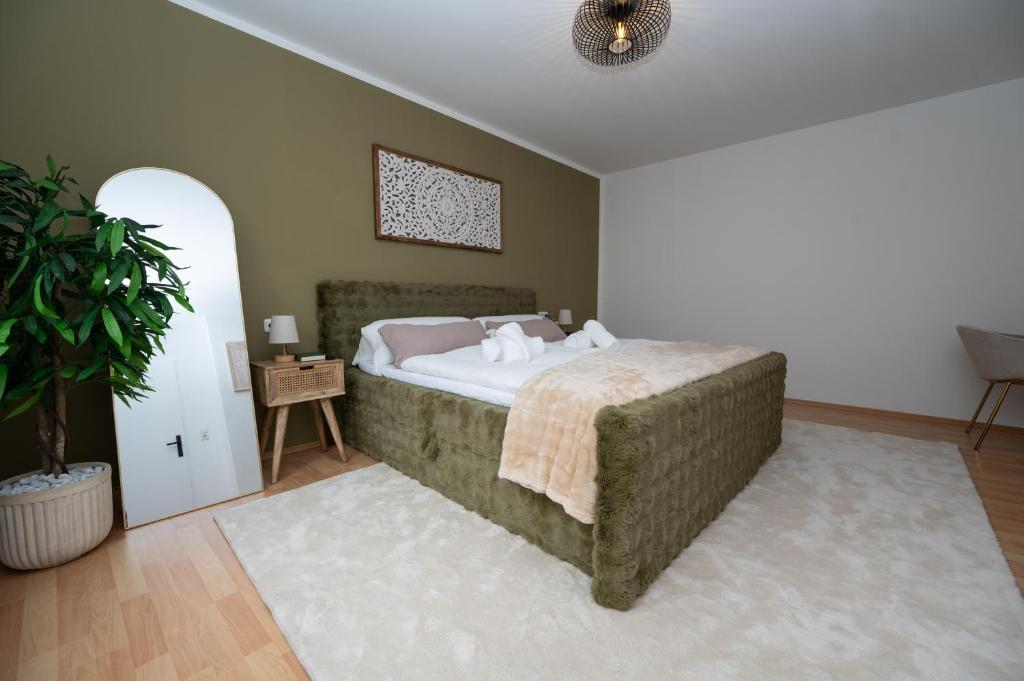 a bedroom with a bed and a potted plant at Green Mango - City Apartment mit Balkon in Mürzzuschlag