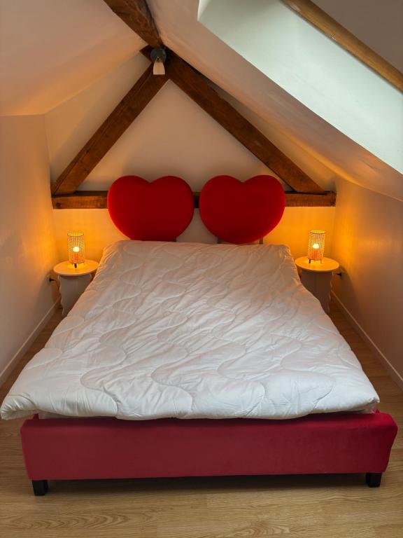 two red hearts on a bed in a attic at Maisonnette in Chambon-sur-Voueize