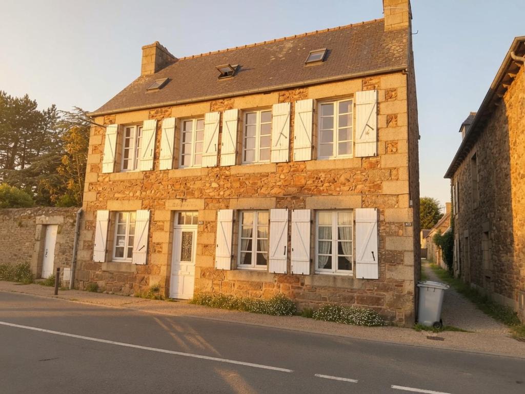 an old brick building on the side of a street at Face à la Mer in Perros-Guirec