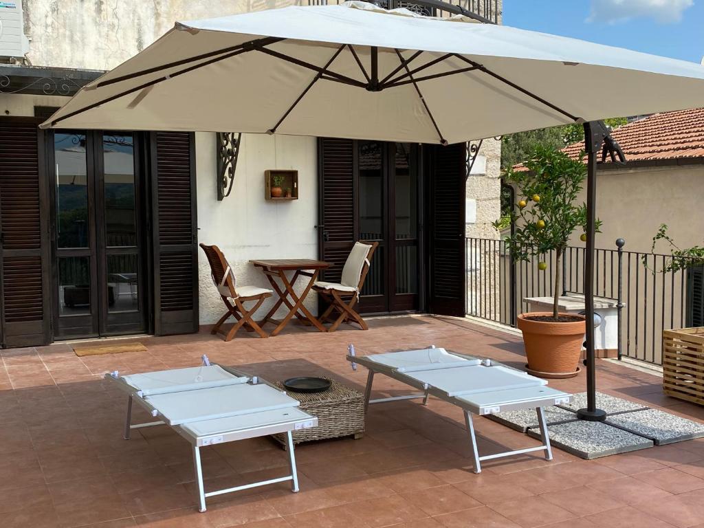 two tables and an umbrella on a patio at Dimora al Borgo Antico in Isernia