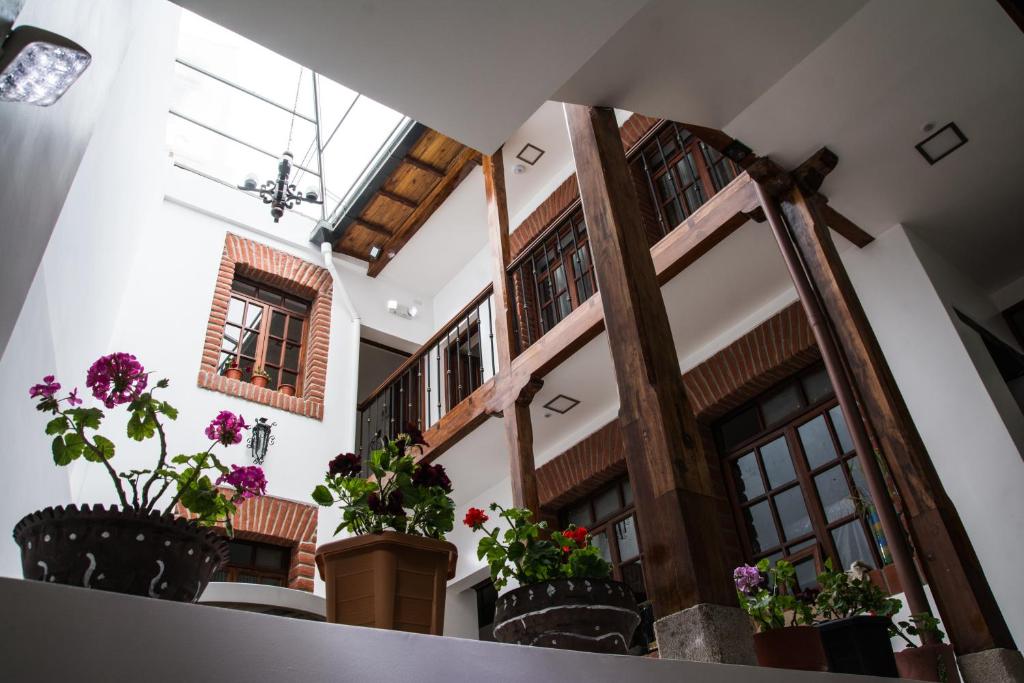 Hotel Casa Ecuatreasures Centro Historico في كيتو: مدخل مع نباتات الفخار في مبنى