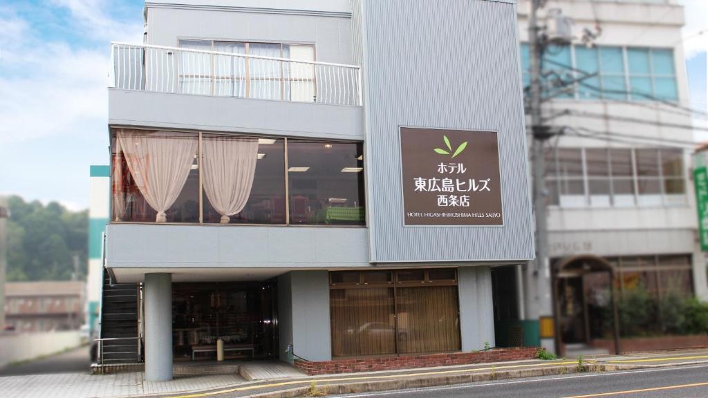 a building with a sign on the side of it at Hotel Higashihiroshima Hills Saijo in Higashihiroshima