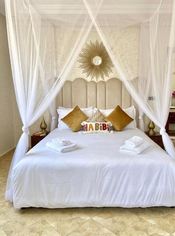 a bedroom with a white bed with a canopy at Marrakech home in Marrakesh