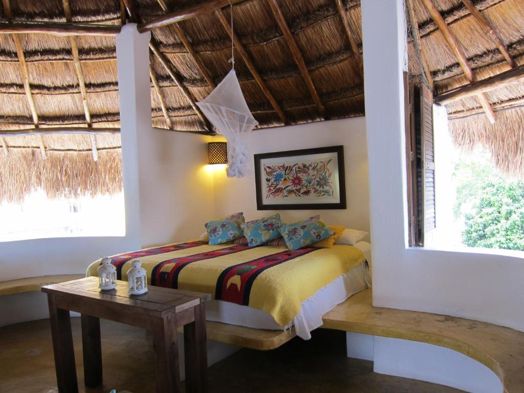 a bedroom with a bed in a room with windows at Amaranto Bed and Breakfast in Cozumel