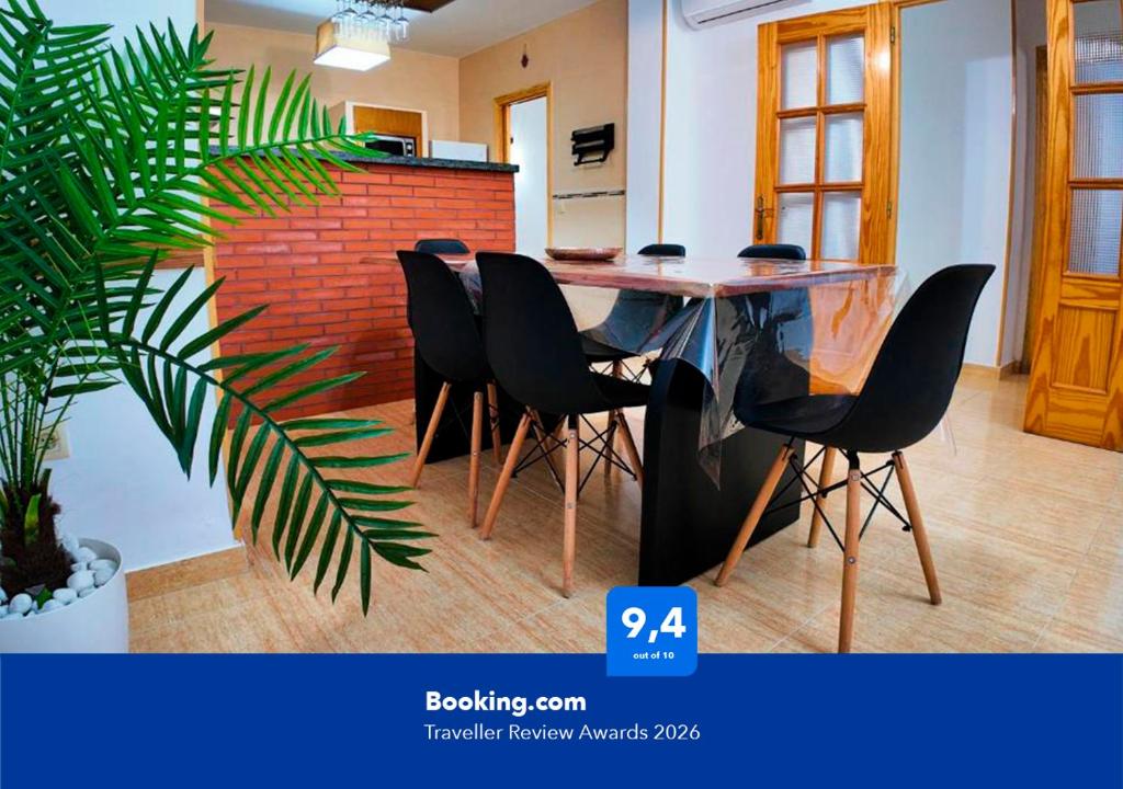 a dining room with a table and black chairs at Apartalux Supreme Suite in Carboneras