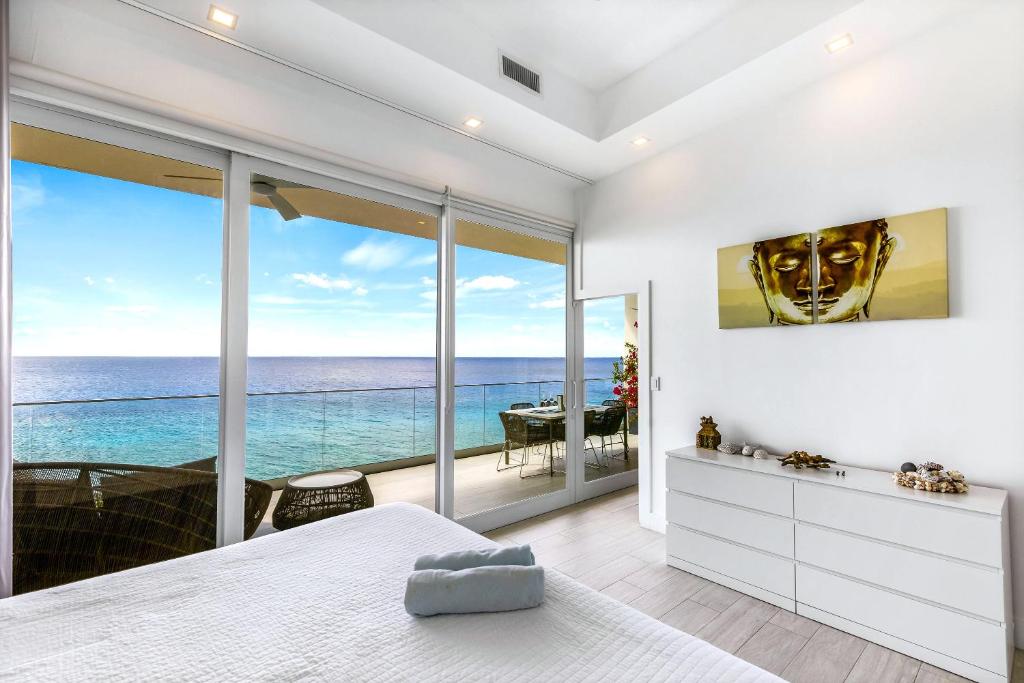 a bedroom with a view of the ocean at Lighthouse Point Residences in West Bay