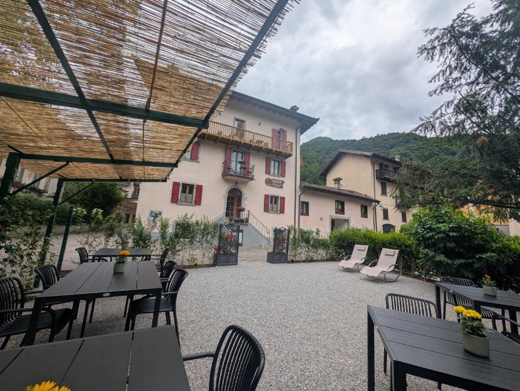 a patio with tables and chairs and a building at Bed and Breakfast Galet in Ledro
