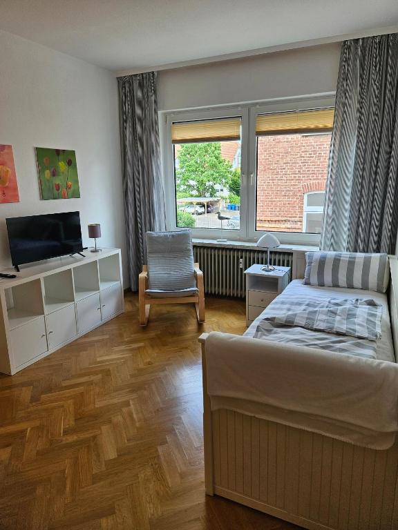 a bedroom with a bed and a chair and a window at City Apartment in Bad Arolsen