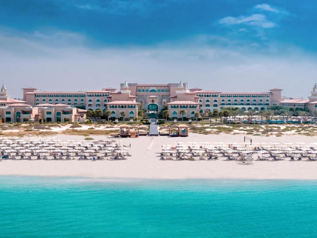 a resort on the beach with chairs and the water at Rixos Premium Saadiyat Island - All Inclusive in Abu Dhabi