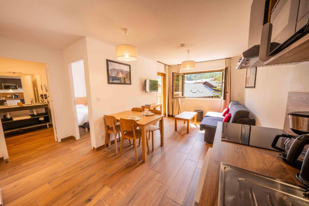 a living room with a kitchen and a dining room at Résidence Arya - Living Stone in Vars