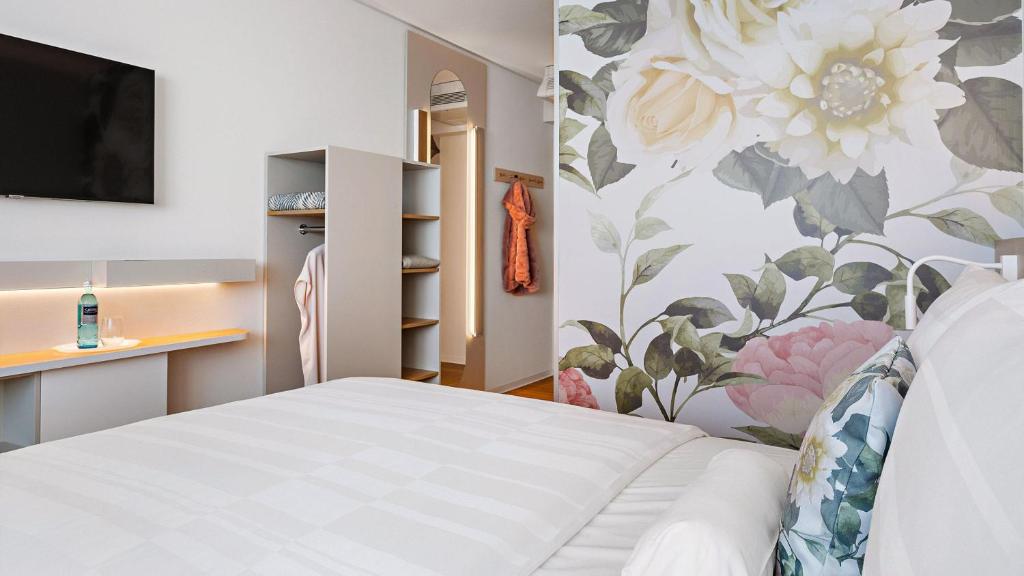 a bedroom with a bed and a wall with flowers at Hey Lou Hotel Karlsruhe Messe in Karlsruhe