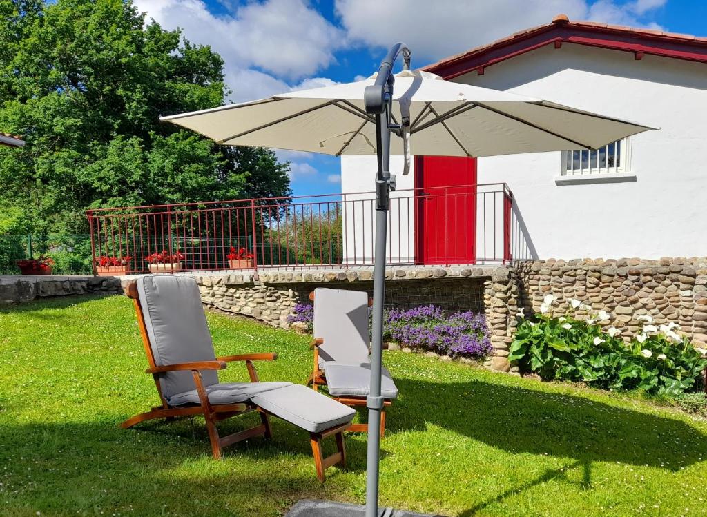 two chairs and an umbrella in a yard at Askatasuna in Itxassou