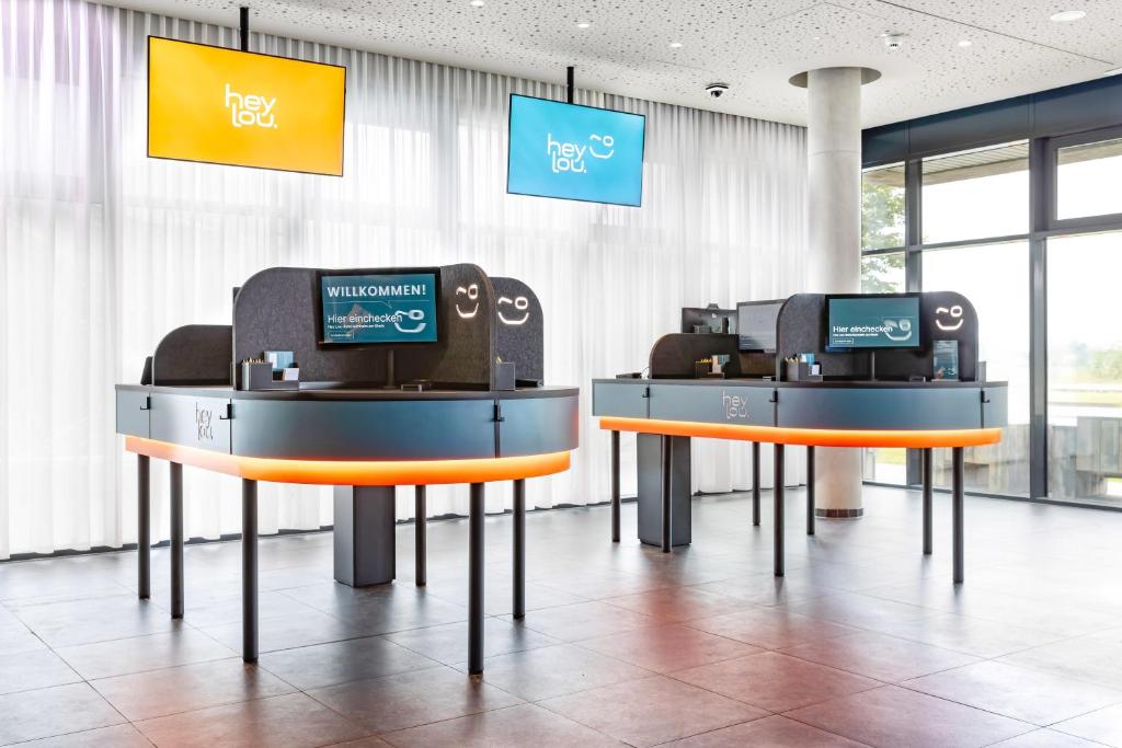 two automated teller machines in a room with windows at Hey Lou Hotel Monheim am Rhein in Monheim