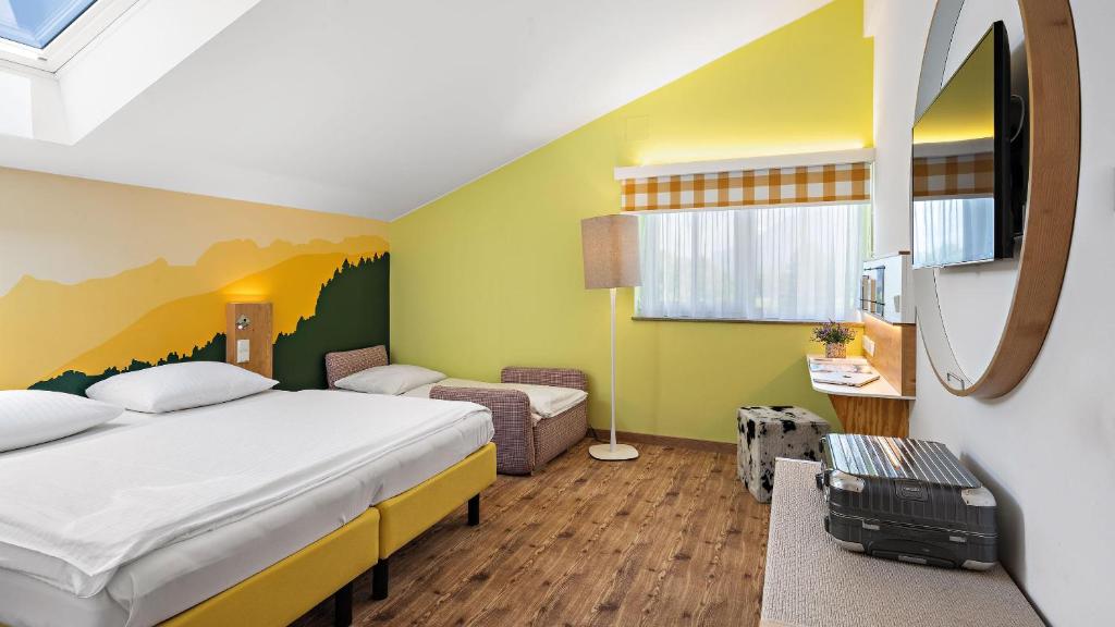 a hotel room with a bed and a mirror at Hey Lou Hotel Piding in Piding