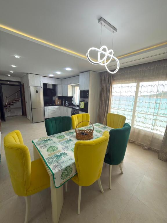 a dining room with a table and yellow chairs at Appartement à plage Dalia in Dalia
