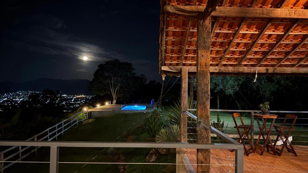 a night view of a patio with a table and chairs at Sítio Espírito Santo in Paraisópolis