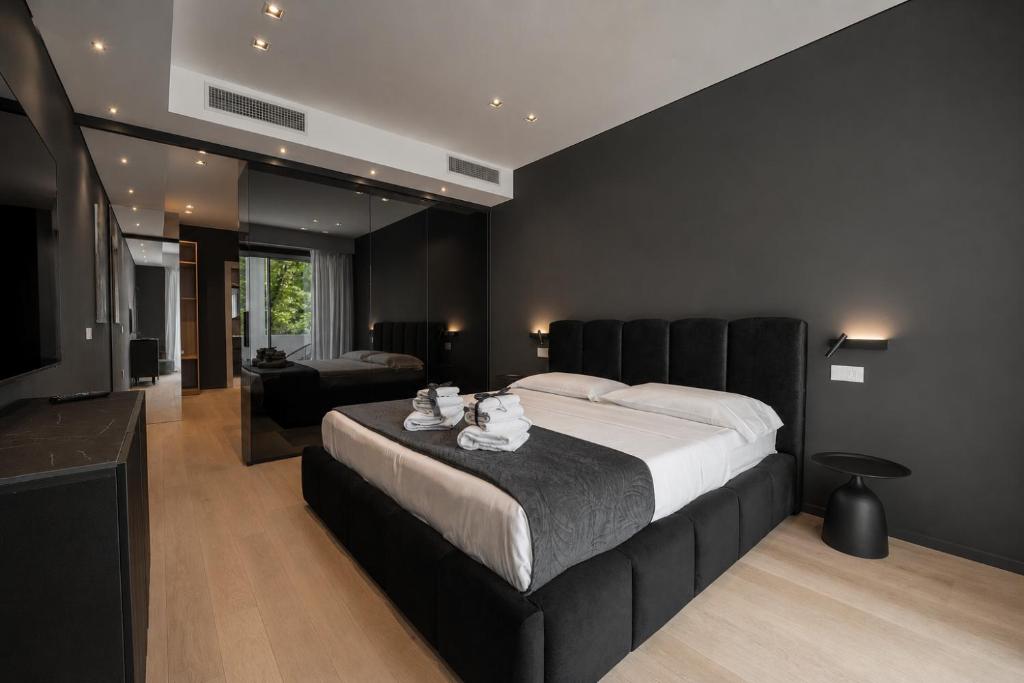 a bedroom with a large bed with a black wall at Roberto Verde House SPECTRE Luxury Suite in Verona