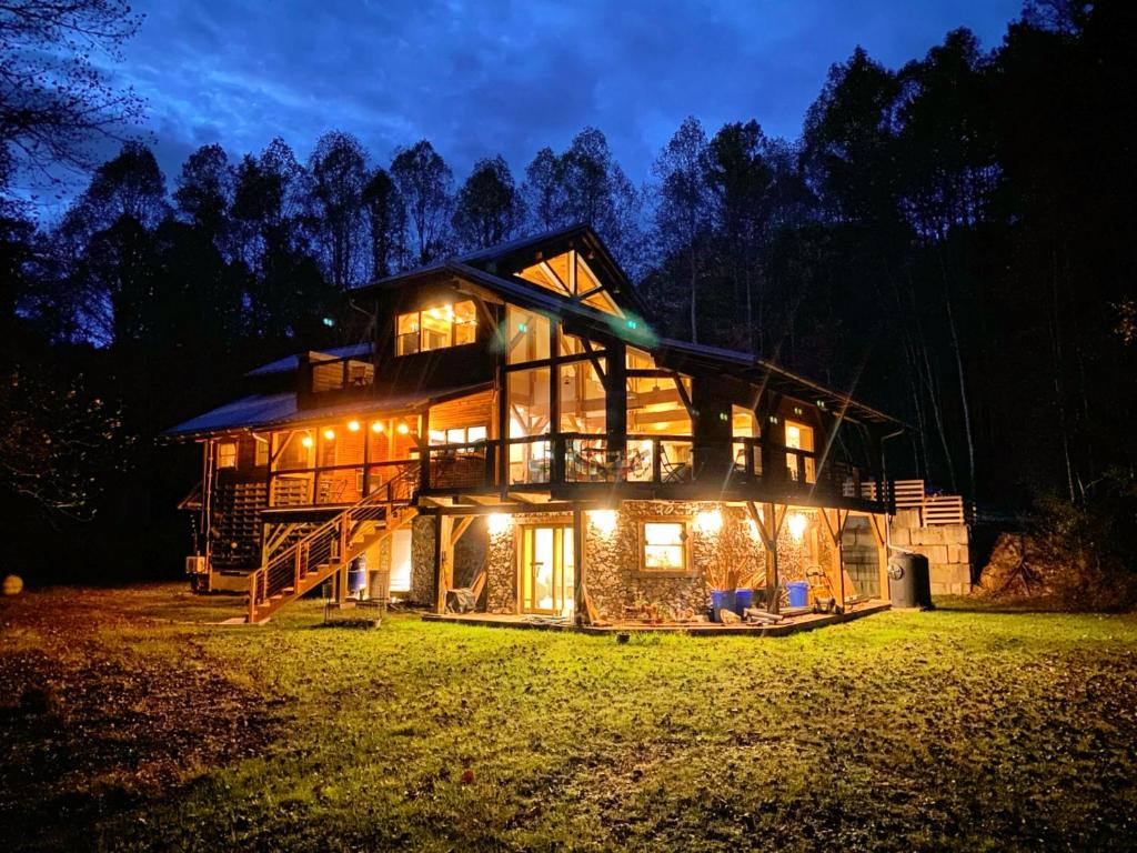 a log cabin at night with lights at The Arete Hostel and Suites in Summersville