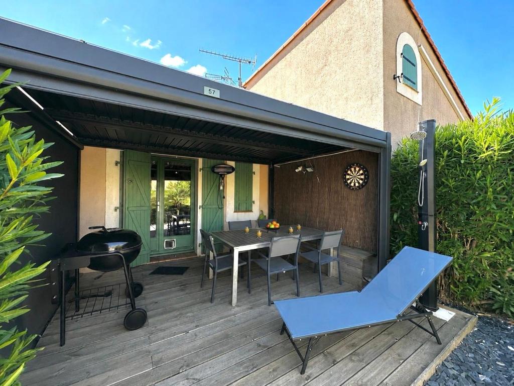 a patio with a table and chairs on a deck at Coul in Valras-Plage