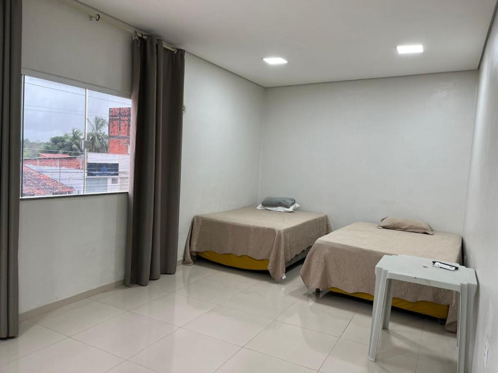 a hospital room with two beds and a window at Dormitório in Barreirinhas