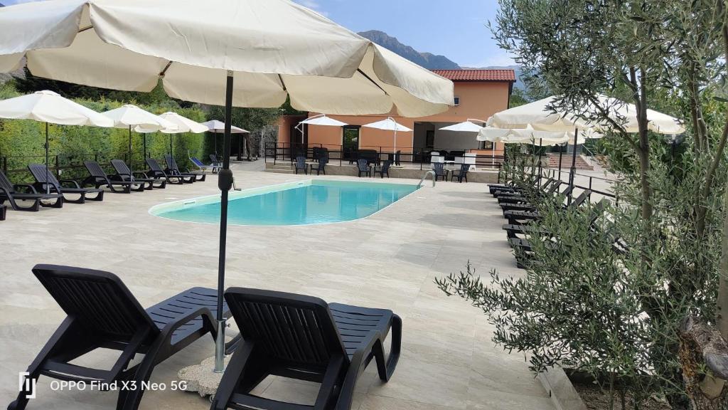 a swimming pool with chairs and umbrellas next to a pool at Villa Rosaria B&B in Morano Calabro