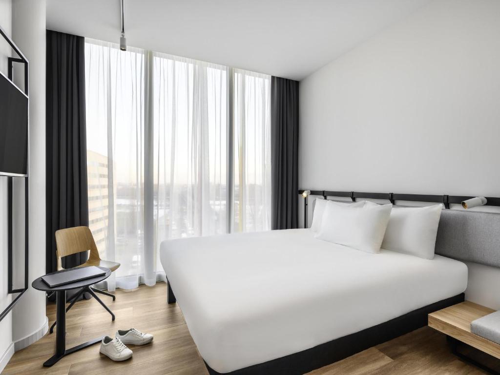 a bedroom with a large white bed and a window at ibis Budapest Stadium in Budapest
