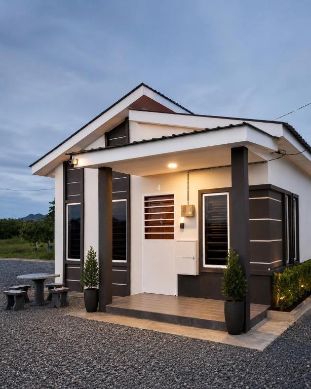 a small house with a bench in front of it at Dmana Homestay Arau Perlis Tiny House in Arau