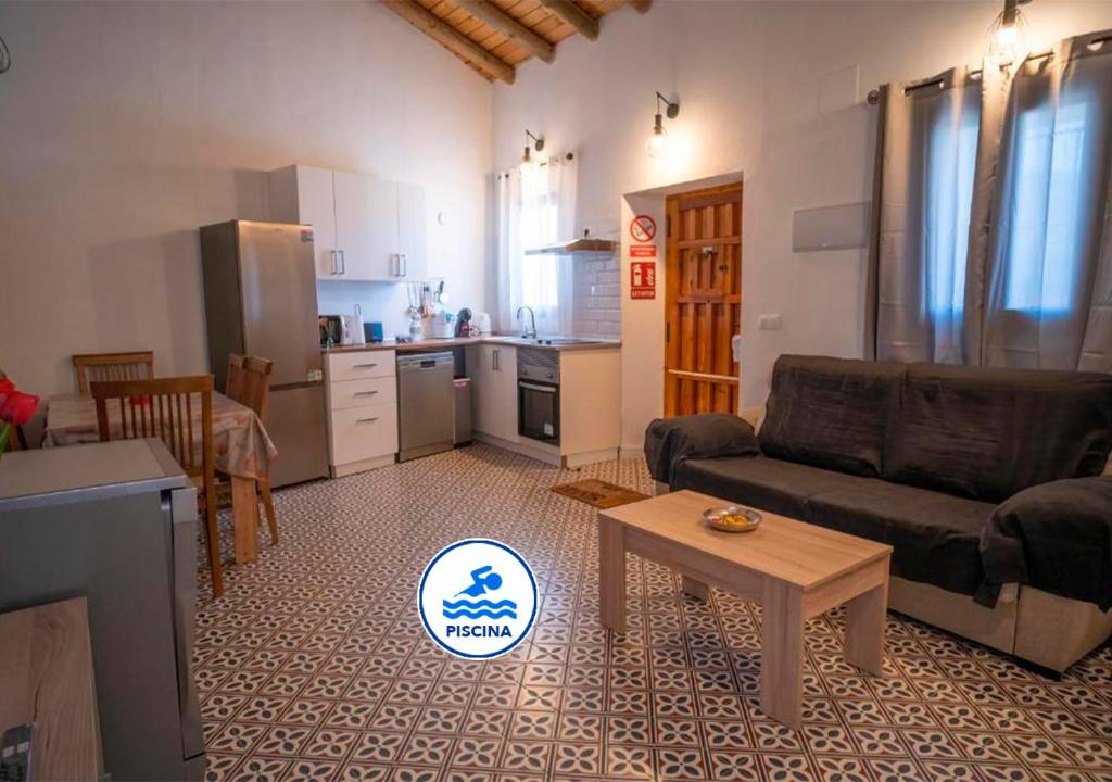 a living room with a couch and a table and a kitchen at Ruralux Aroche in Aroche