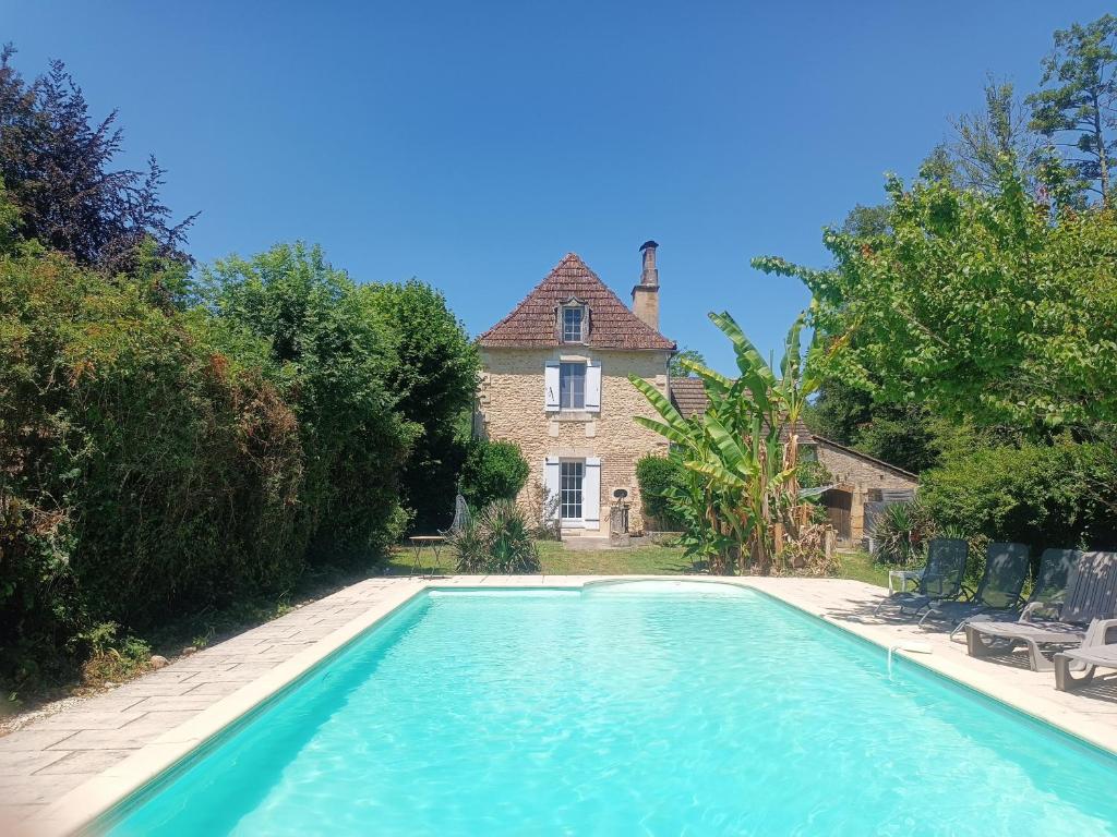 a swimming pool in front of a house at Villa EsquirHall, chambres d'hôtes in Journiac
