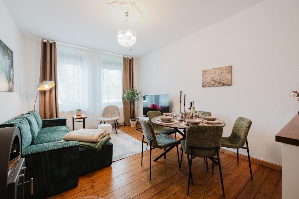 a living room with a green couch and a table at Altbau-Traum, Zentrumsnah, Küche, Whirlpool in Braunschweig