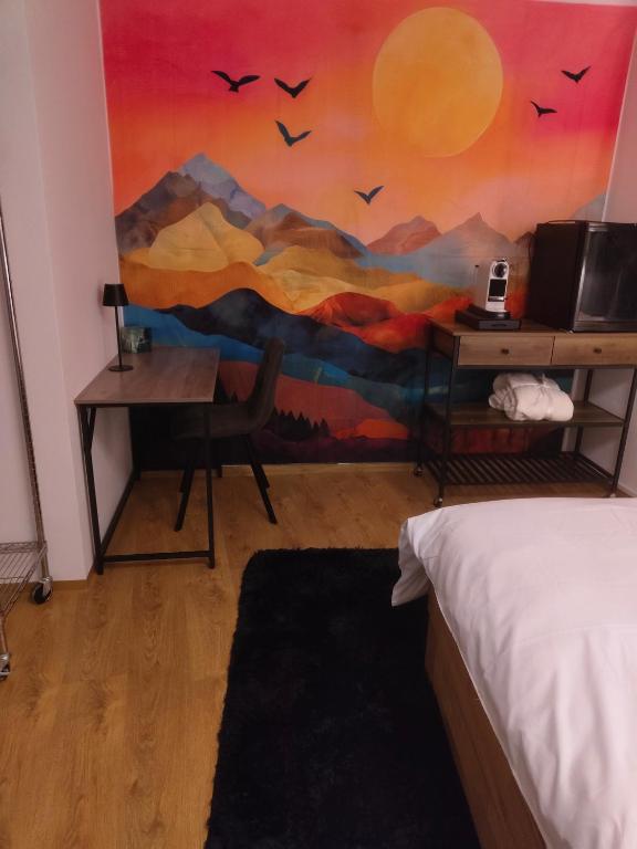 a bedroom with a painting of mountains and birds at Zentrum & Therme in Bad Wörishofen