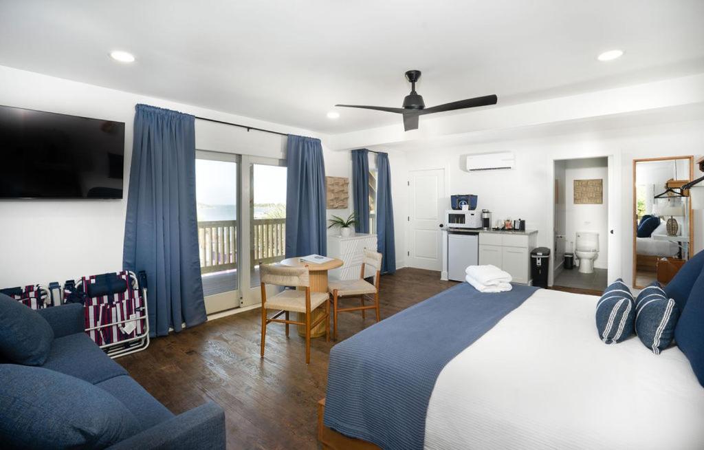a bedroom with a bed and a table and a couch at The Silver Lake Hotel at Ocracoke in Ocracoke