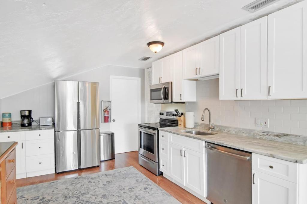 a kitchen with white cabinets and stainless steel appliances at Sanibel Sandals & Flip Flops in Sanibel