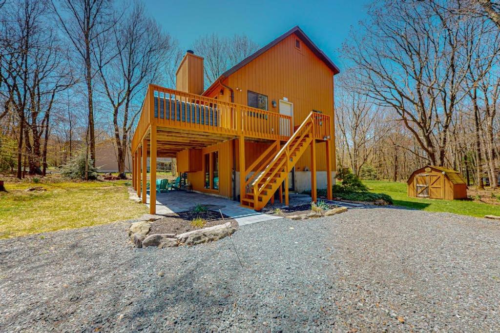 a large orange house with a staircase on it at The Burrow in Jim Thorpe