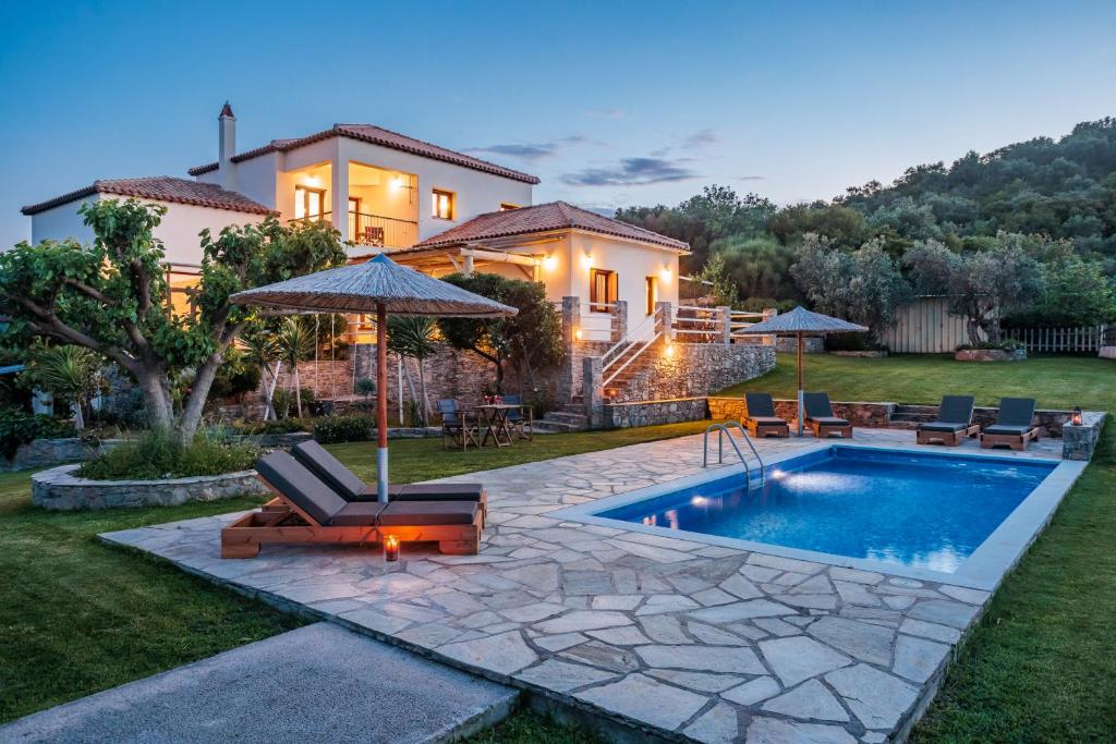 a home with a swimming pool and a house at Villa Anatoli in Skopelos Town