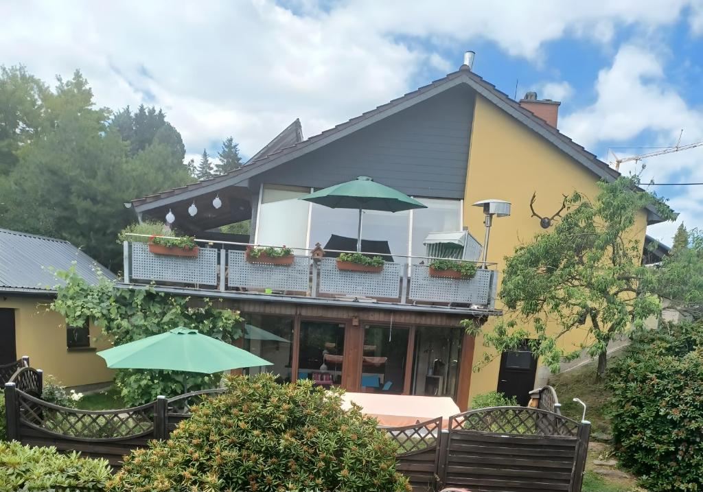 a house with a balcony with umbrellas at Ferienwohnung Heidi in Bielatal