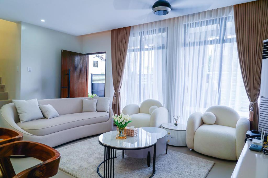 a living room with a white couch and a table at Casa Gomes Amuntay in Dasmariñas