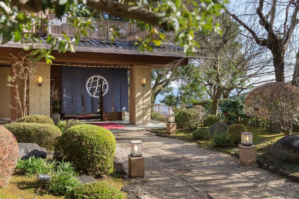 a garden with a pathway leading to a house at Watei Kazekomichi in Atami
