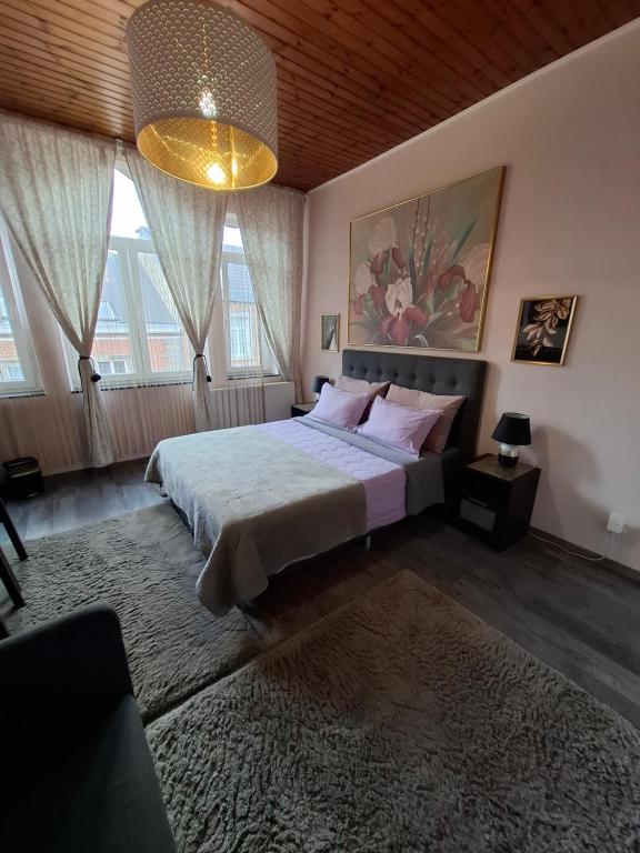 a bedroom with a large bed and a chandelier at Room De LUX SPA " TABARKA " in Spa