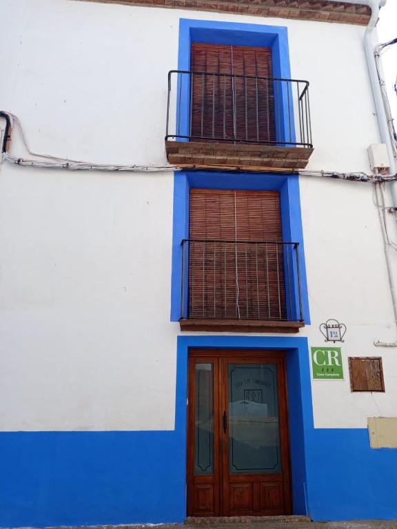 a blue and white building with a door and balcony at Los Chinchanes in Santa Cruz de Grío