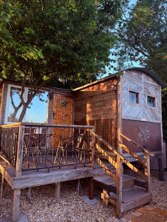 a wooden cabin with a bench in front of it at The Cosy Nest Hut in Keddington