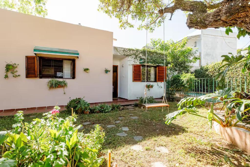 a white house with a garden in front of it at Hospedaje La Casa del Ceibo in Córdoba